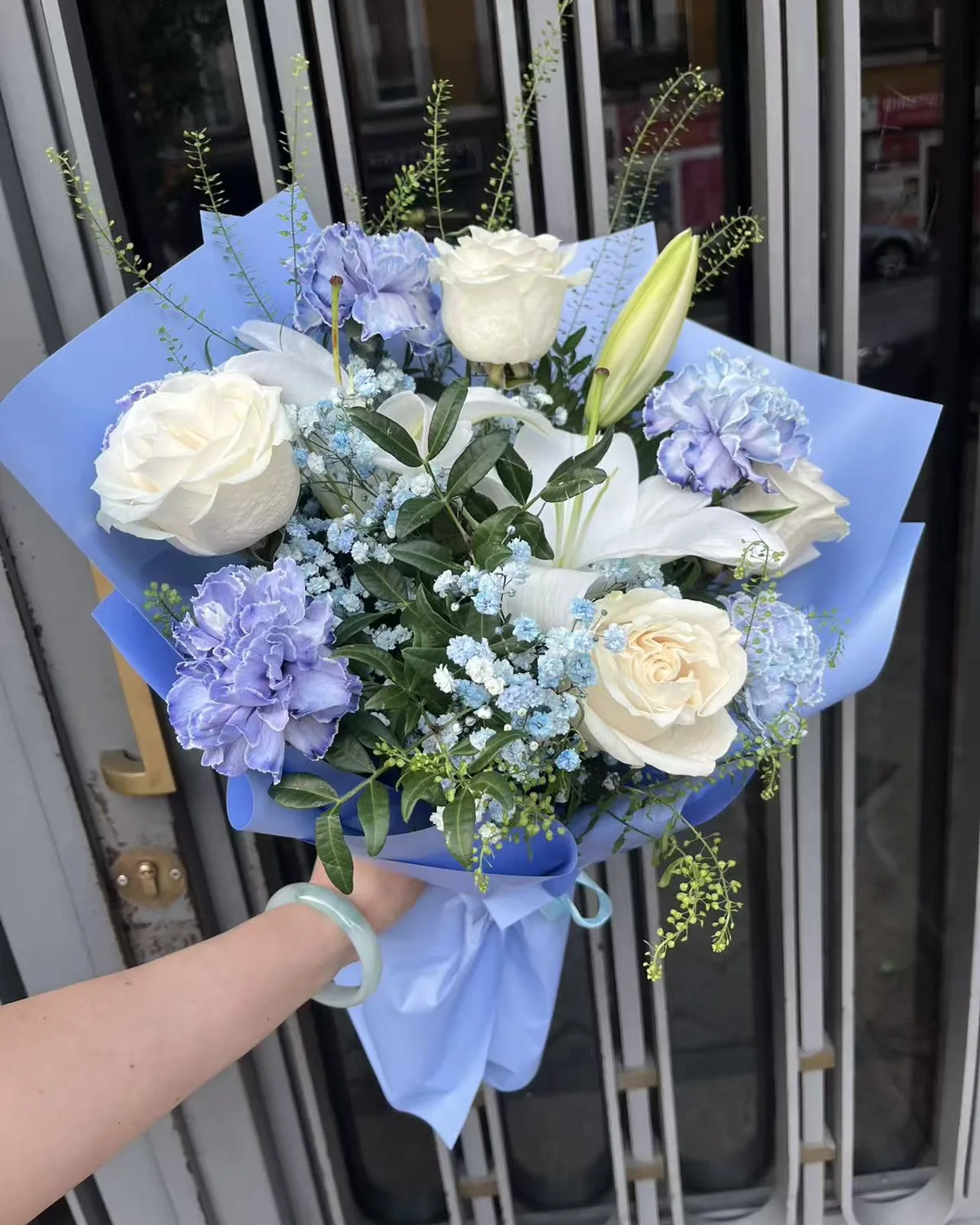 Ramo Cielo de rosas blancas, lilium y claveles azules con paniculata azul en papel azul