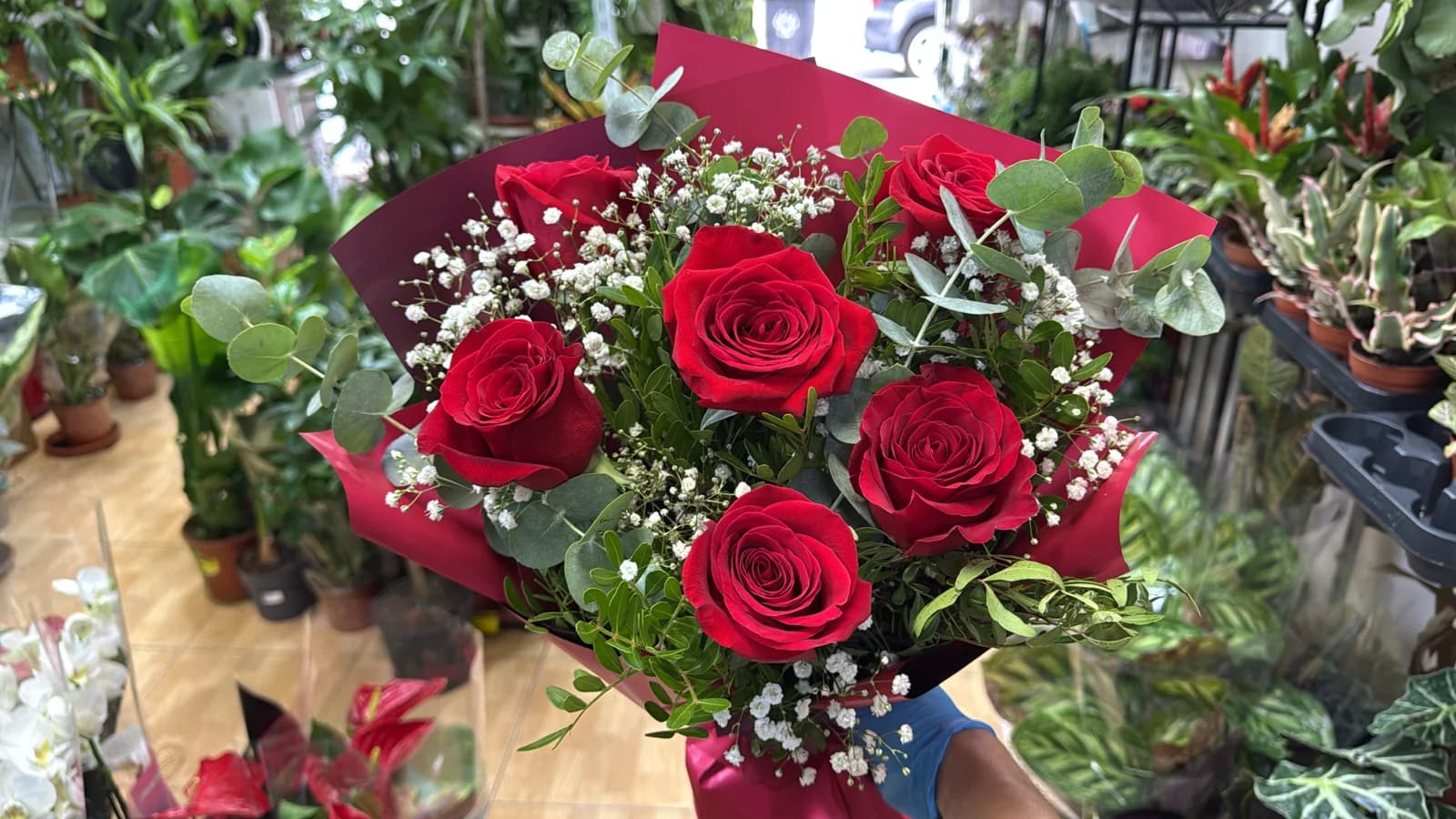 Bouquet of red roses with baby's breath in black and white paper with a ribbon
